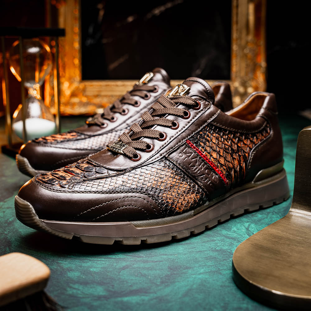 The Marco Di Milano Brescia Washed Cognac sneakers feature brown leather with a snakeskin pattern, gold accents, and rubber soles; one shoe is propped stylishly against the other, showcasing luxury footwear appeal.