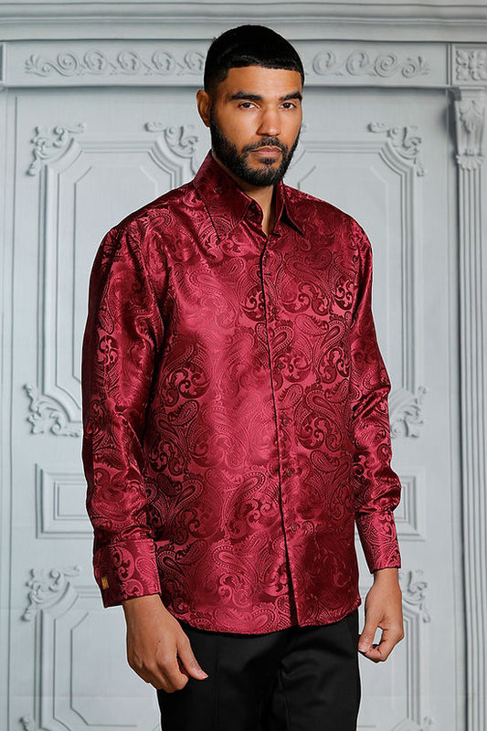 A man stands before an ornate white wall wearing the Manzini MZT-100 Paisley Long Sleeve Satin Burgundy Shirt with links by Manzini.