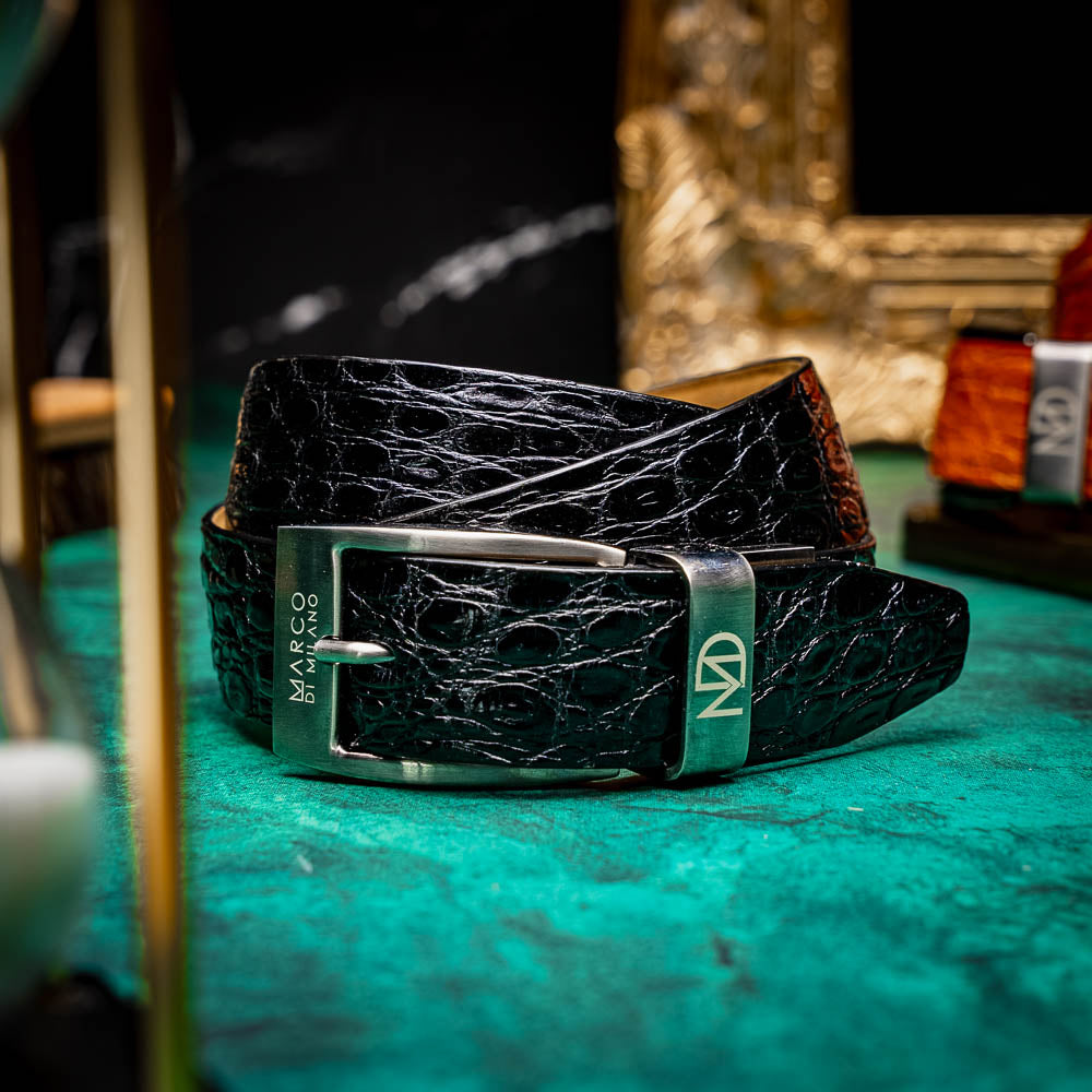 The Massimo Belt Black by Marco Di Milano is crafted from black crocodile-pattern leather with a metallic buckle engraved "Marco Di Milano" and "MD," featuring hand-painted finishes to complement luxury footwear collections.