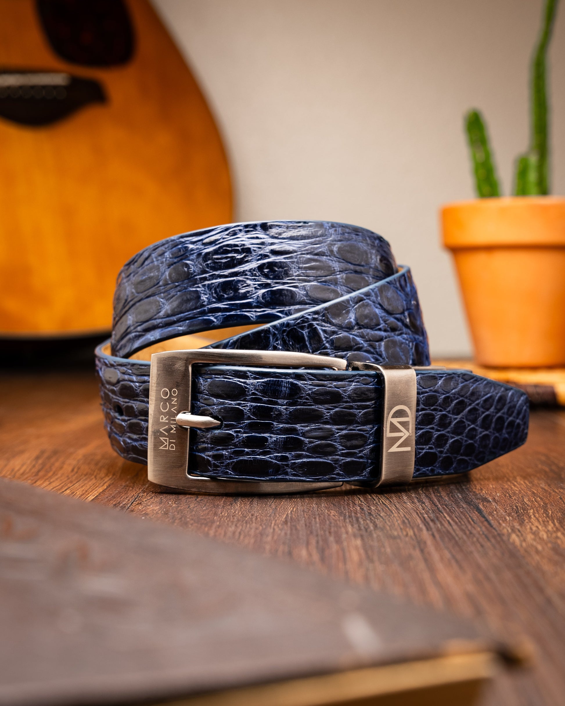 The Massimo Belt Navy by Marco Di Milano features blue crocodile-embossed leather, a silver rectangular buckle engraved with "MD," inspired by genuine caiman flank belts, and finished with elegant hand-painted details.