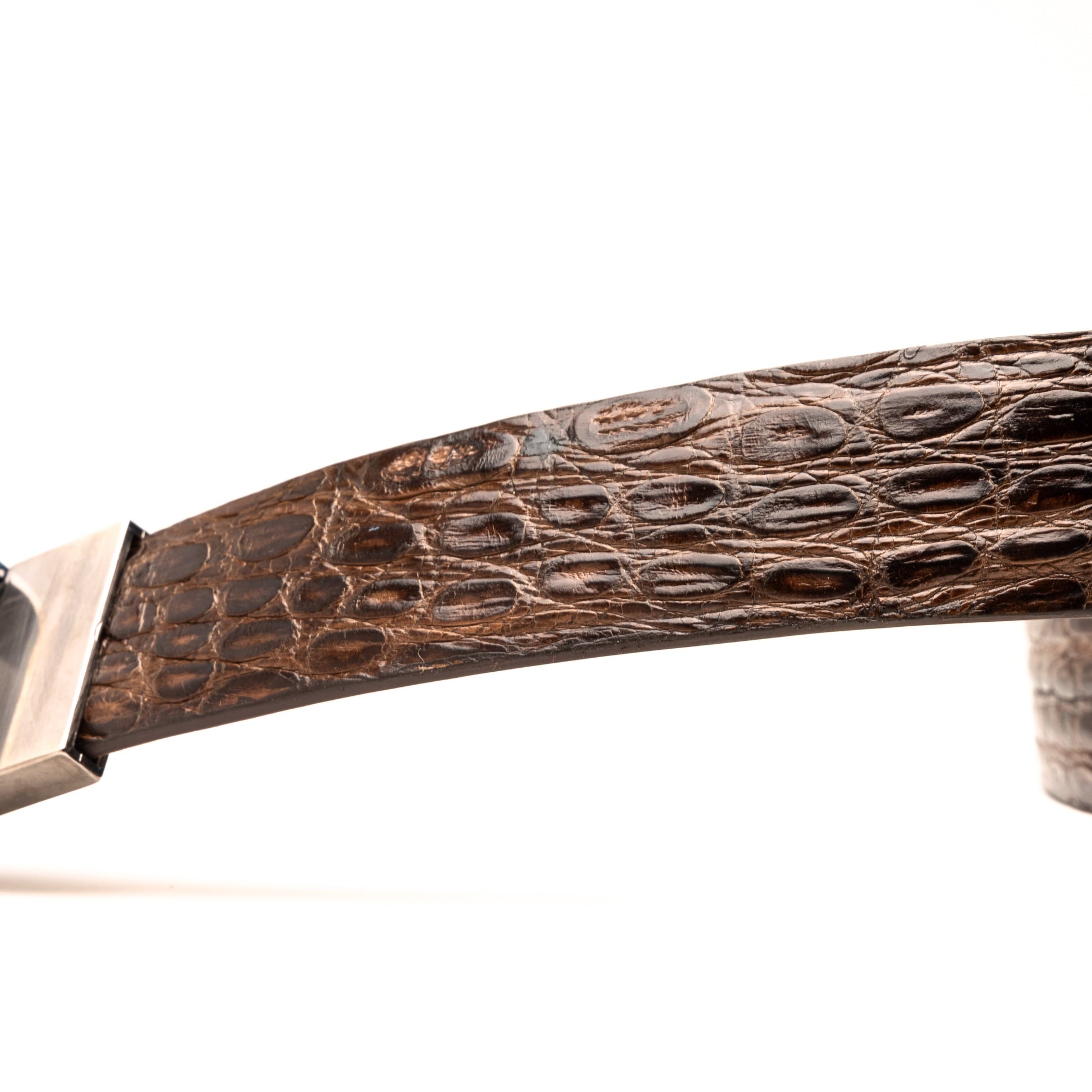 The Massimo Belt Brown by Marco Di Milano features an exotic caiman flank design and a silver engraved buckle—an elegant accessory to pair with your luxury footwear collection.