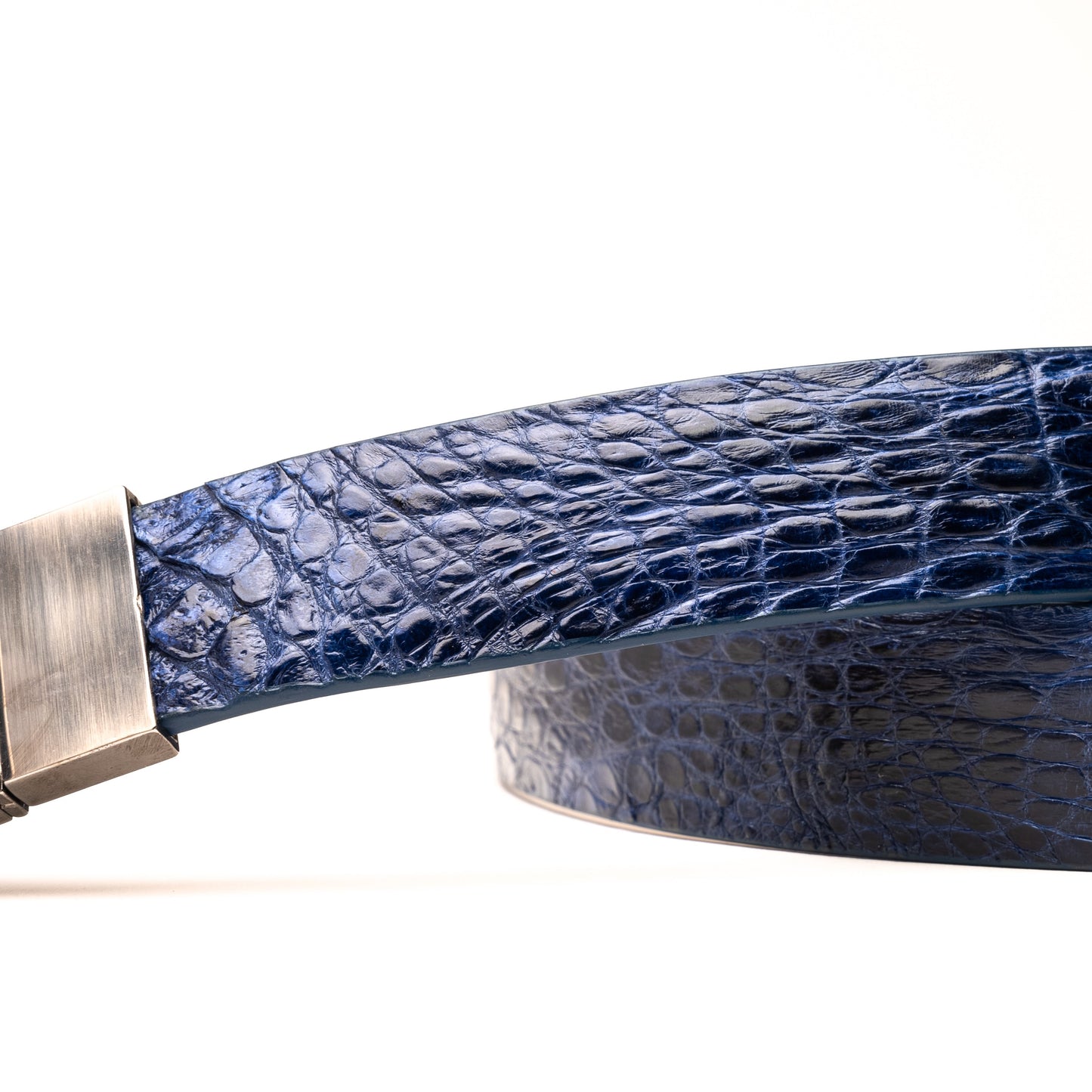 The Massimo Belt Navy by Marco Di Milano features blue crocodile-embossed leather, a silver rectangular buckle engraved with "MD," inspired by genuine caiman flank belts, and finished with elegant hand-painted details.