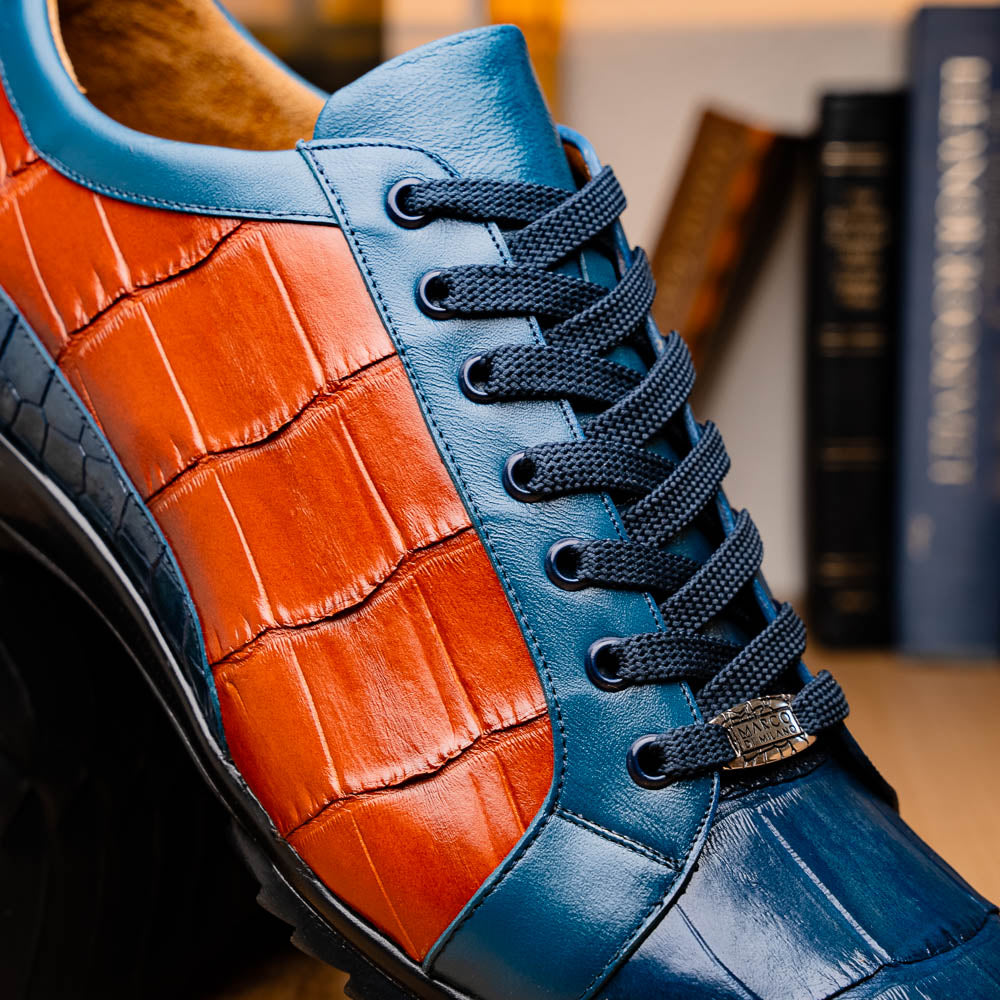 The Marco Di Milano Cairo Blue Jeans/Honey low-top sneakers showcase blue and orange genuine alligator leather with black laces and textured black rubber soles for a luxurious look.