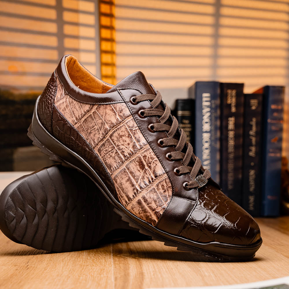 The Marco Di Milano Cairo Brown/Orix men's sneakers feature brown luxury footwear with textured panels and rubber soles, crafted to resemble genuine alligator. One shoe stands upright while the other lies on its side.