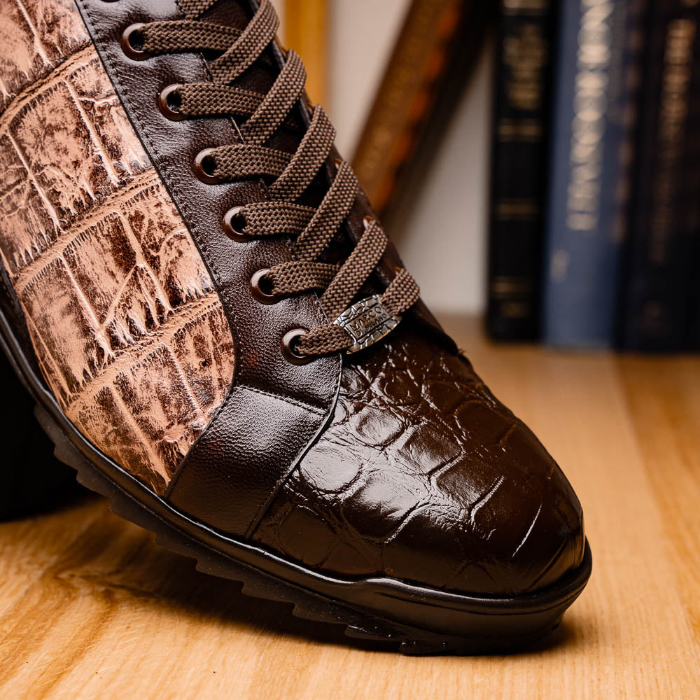 The Marco Di Milano Cairo Brown/Orix men's sneakers feature brown luxury footwear with textured panels and rubber soles, crafted to resemble genuine alligator. One shoe stands upright while the other lies on its side.