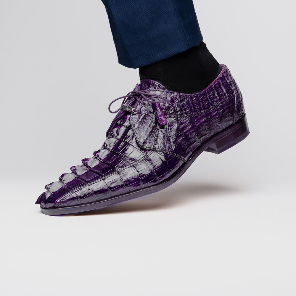 The Marco Di Milano Cancun Purple is a luxurious pair of derby shoes crafted from genuine hornback caiman crocodile leather, hand-painted in purple with black laces—one shown upright, the other displaying a tan branded sole.