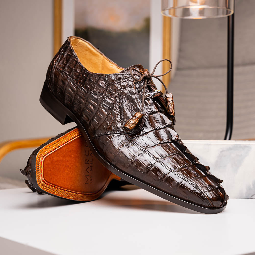 A pair of Marco Di Milano Cancun Brown derby shoes in dark brown hornback caiman crocodile leather—one displays the textured upper, while the other reveals the hand-painted exotic sole embossed with the brand.