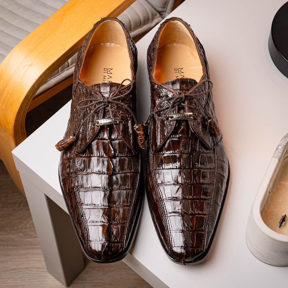 A pair of Marco Di Milano Cancun Brown derby shoes in dark brown hornback caiman crocodile leather—one displays the textured upper, while the other reveals the hand-painted exotic sole embossed with the brand.