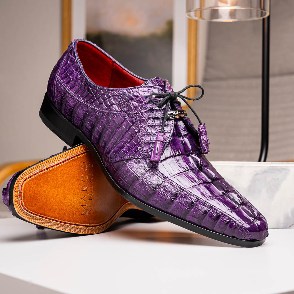 The Marco Di Milano Cancun Purple is a luxurious pair of derby shoes crafted from genuine hornback caiman crocodile leather, hand-painted in purple with black laces—one shown upright, the other displaying a tan branded sole.