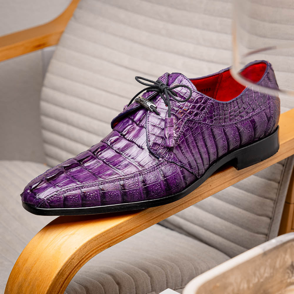 The Marco Di Milano Cancun Purple is a luxurious pair of derby shoes crafted from genuine hornback caiman crocodile leather, hand-painted in purple with black laces—one shown upright, the other displaying a tan branded sole.