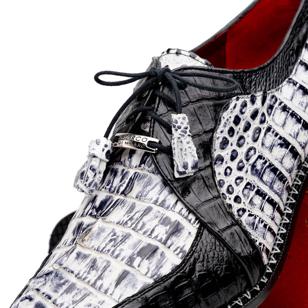 A pair of Marco Di Milano Caribe Newspaper / Black luxury dress shoes crafted from genuine hornback caiman crocodile leather, with one upright and the other on its side showing the brown sole and exquisite hand-painted details.