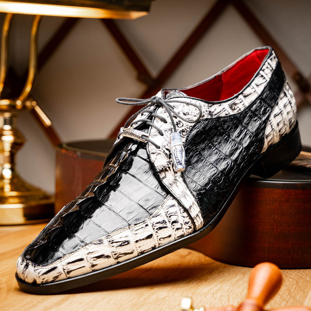 The Marco Di Milano Caribe Black / Newspaper are luxury men's derby shoes crafted from genuine hornback caiman crocodile leather in black and white, featuring red lining, leather soles, lace-up closures, and decorative tassels.