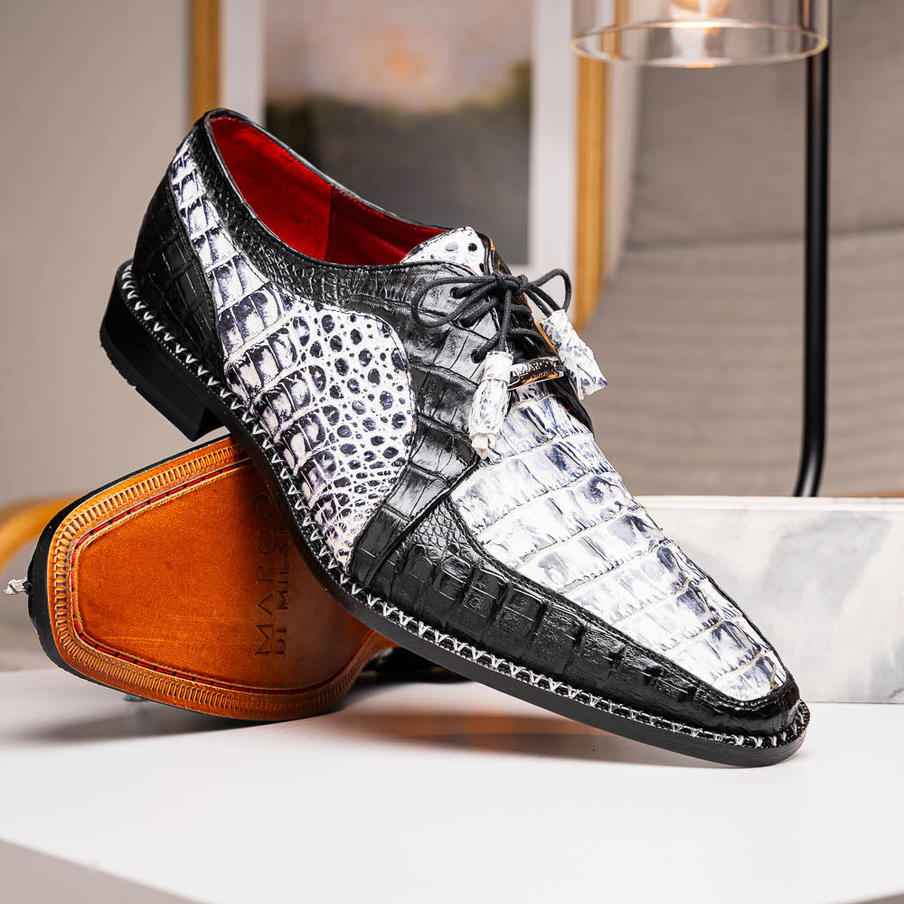 A pair of Marco Di Milano Caribe Newspaper / Black luxury dress shoes crafted from genuine hornback caiman crocodile leather, with one upright and the other on its side showing the brown sole and exquisite hand-painted details.