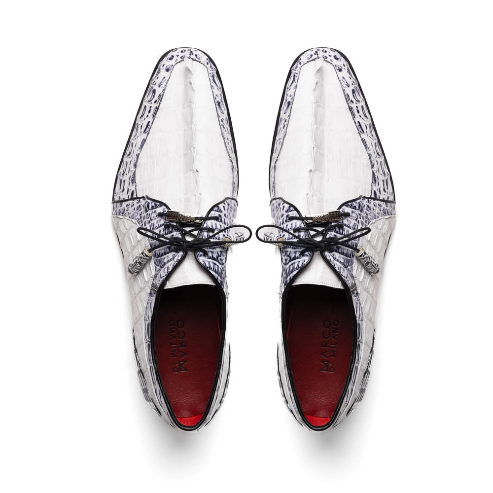 The Marco Di Milano Caribe White / Newspaper Derby shoes feature white and black crocodile-patterned leather, one upright and one on its side to showcase a brown leather sole with red stitching—distinctive, exotic hand-painted footwear.