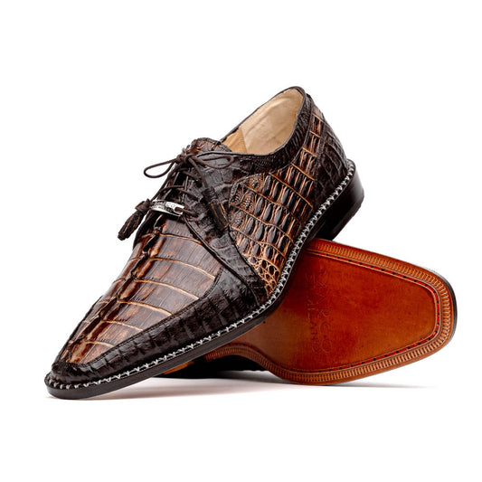 The Marco Di Milano Caribe Rustic Orix/Brown features luxury derby shoes crafted from genuine hornback caiman crocodile leather, with one upright and the other on its side showcasing a tan sole, visible stitching, and hand-painted finishes.