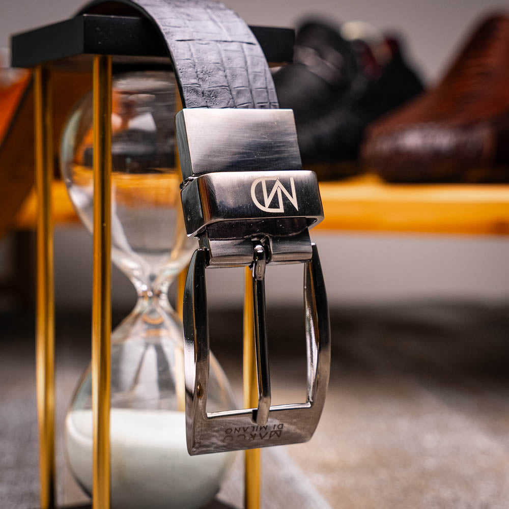 The Caribe Belt Newspaper / Black by Marco Di Milano features rolled black leather, a newspaper-textured white and black tip, and a silver engraved buckle—an elegant statement of luxury exotic belts.