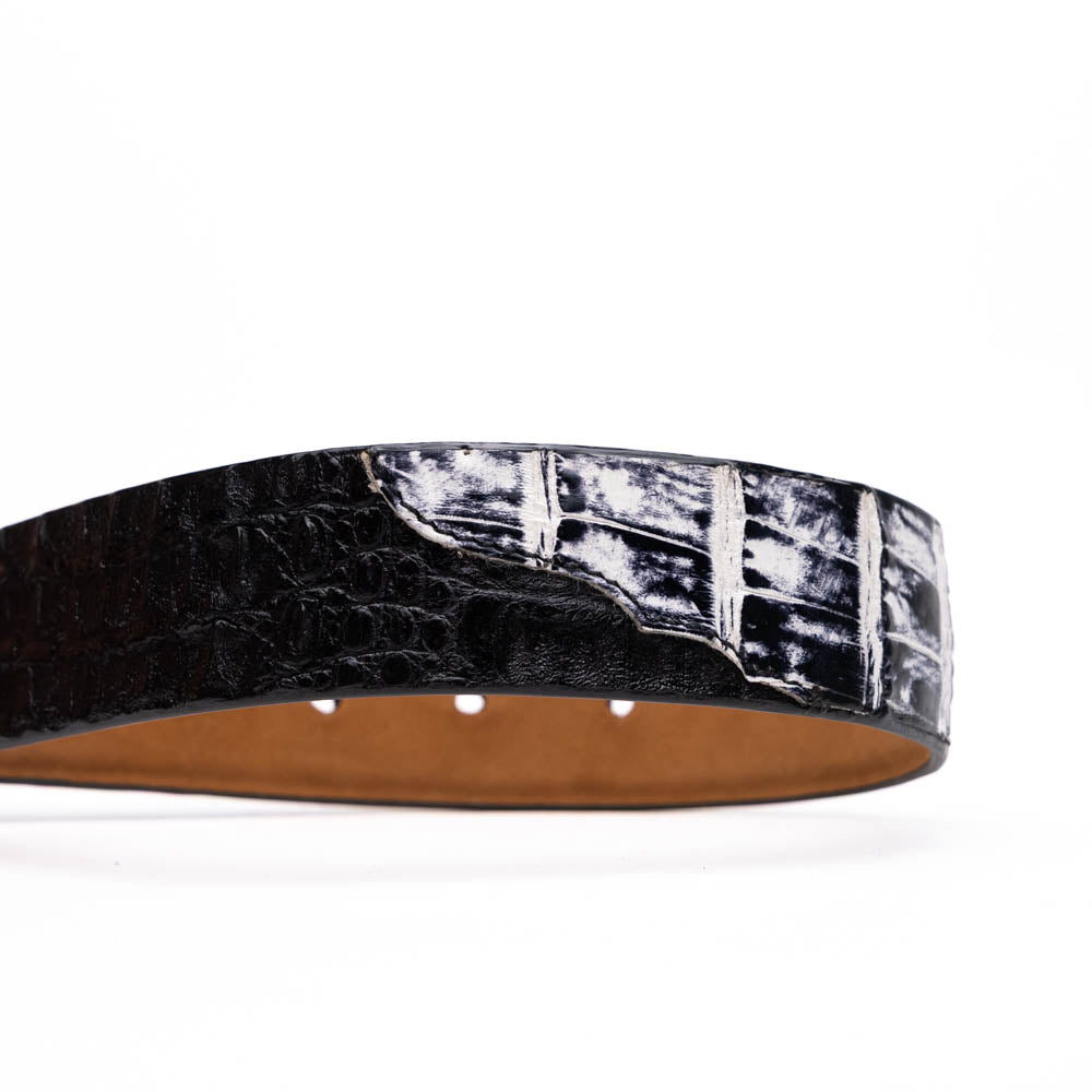 The Caribe Belt Newspaper / Black by Marco Di Milano features rolled black leather, a newspaper-textured white and black tip, and a silver engraved buckle—an elegant statement of luxury exotic belts.
