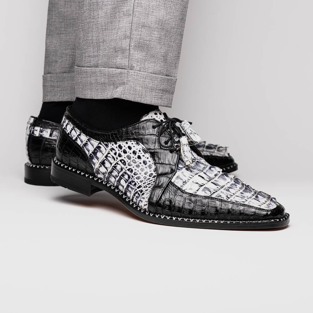 A pair of Marco Di Milano Caribe Newspaper / Black luxury dress shoes crafted from genuine hornback caiman crocodile leather, with one upright and the other on its side showing the brown sole and exquisite hand-painted details.