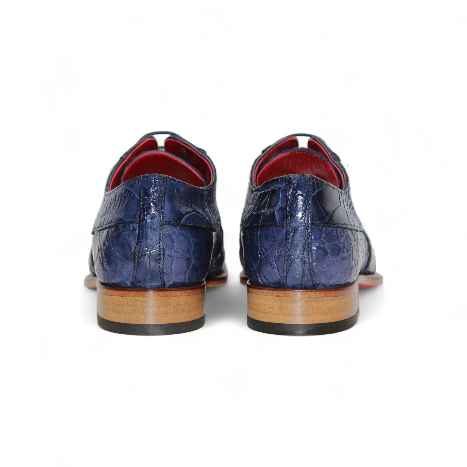 The Fennix Charles Ocean Blue by Fennix of Italy is a navy crocodile-pattern leather dress shoe with a pointed toe, brown sole, and red interior accents, highlighting Italian craftsmanship in a profile view on a white background.
