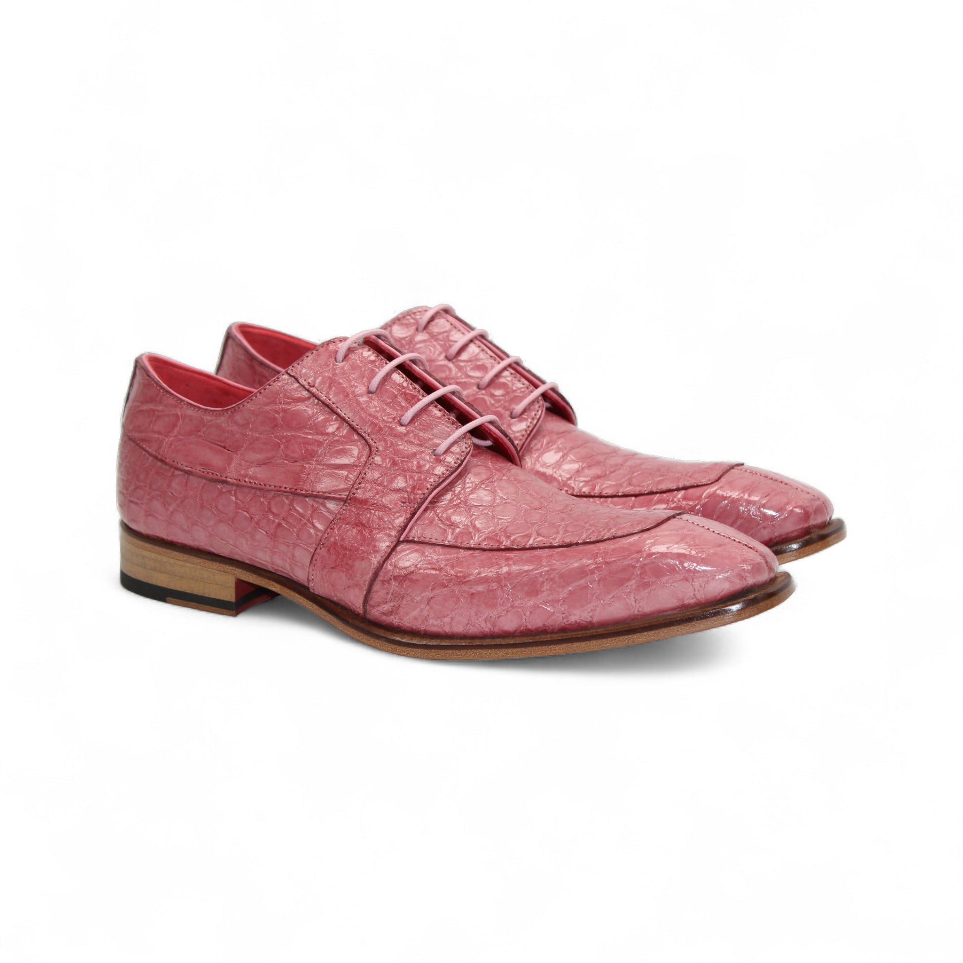 The Fennix of Italy "Fennix Charles Antique Pink" dress shoe features a pink crocodile-patterned leather upper, lace closure, and a wooden sole, showcased in profile on a white background.