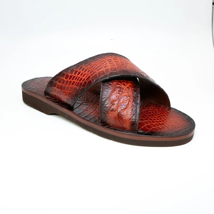 The Elios Cognac sandal by Marco Di Milano features brown textured crossing straps, a flat sole, luxury materials, and hand-painted finishes, all showcased on a white background.