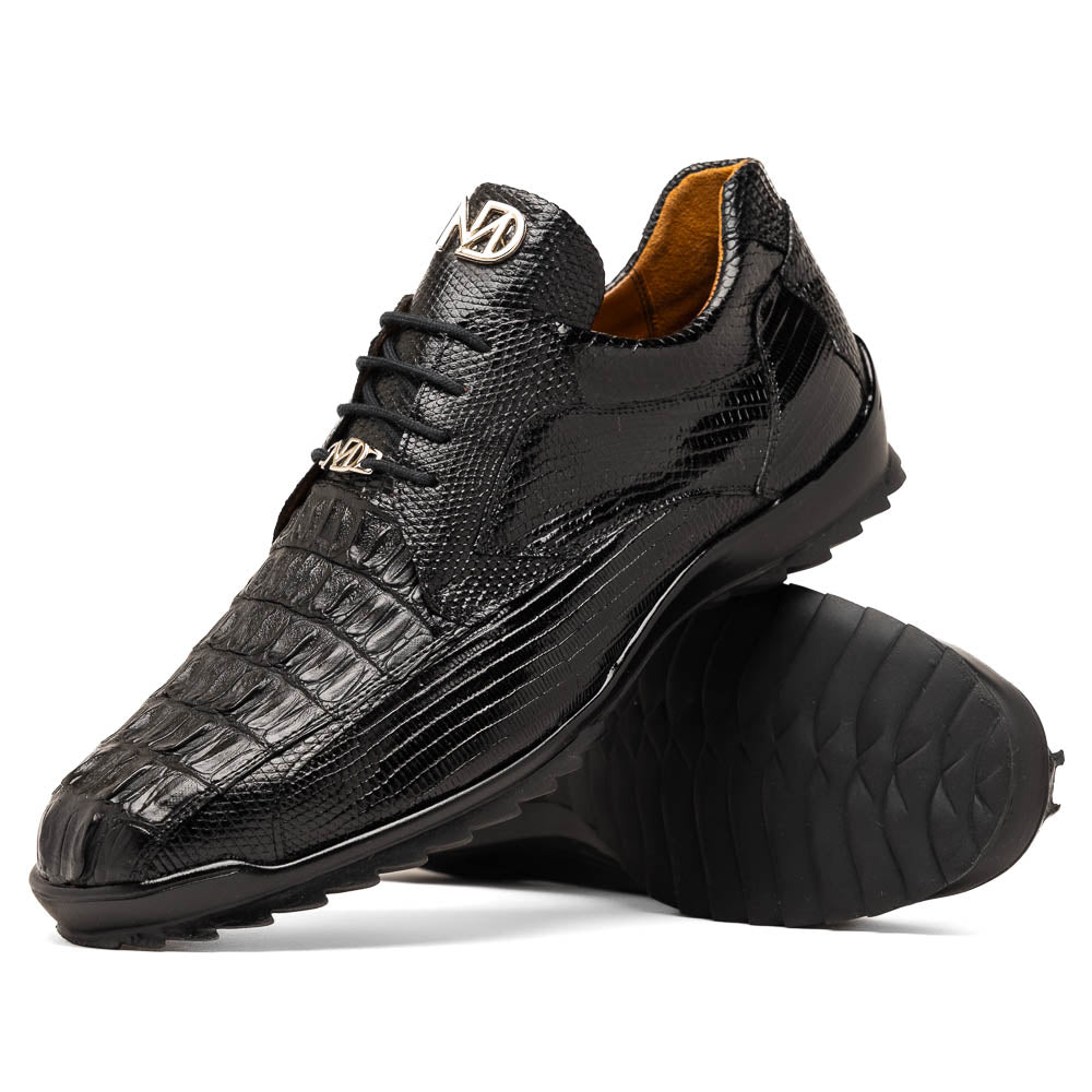 The Crater Black by Marco Di Milano features black textured leather with a crocodile pattern and metallic logo accents, exemplifying genuine exotic shoe craftsmanship—one shoe stands upright, the other lies on its side.