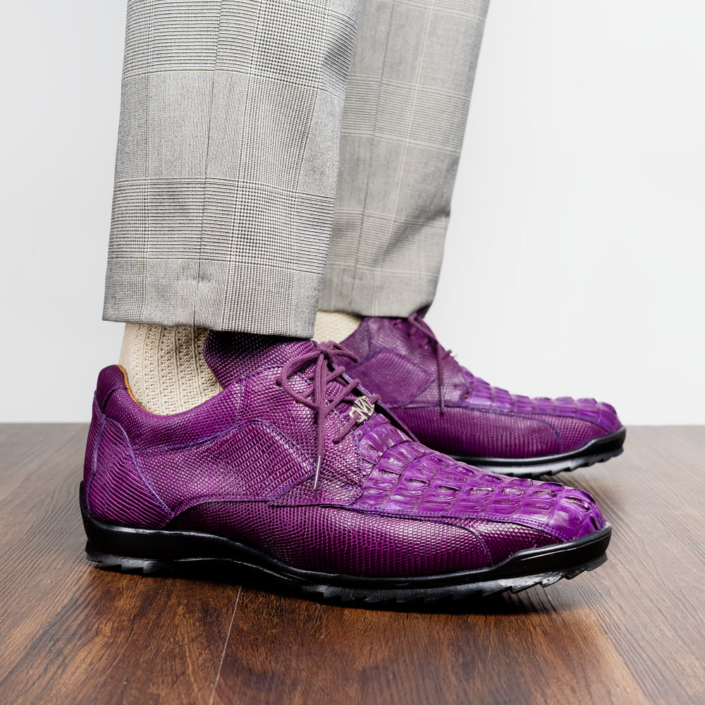 The Marco Di Milano Crater Purple sneakers showcase bold, textured elegance with their purple lizard skin and black rubber soles—luxury men’s footwear where one sneaker stands upright and the other leans.