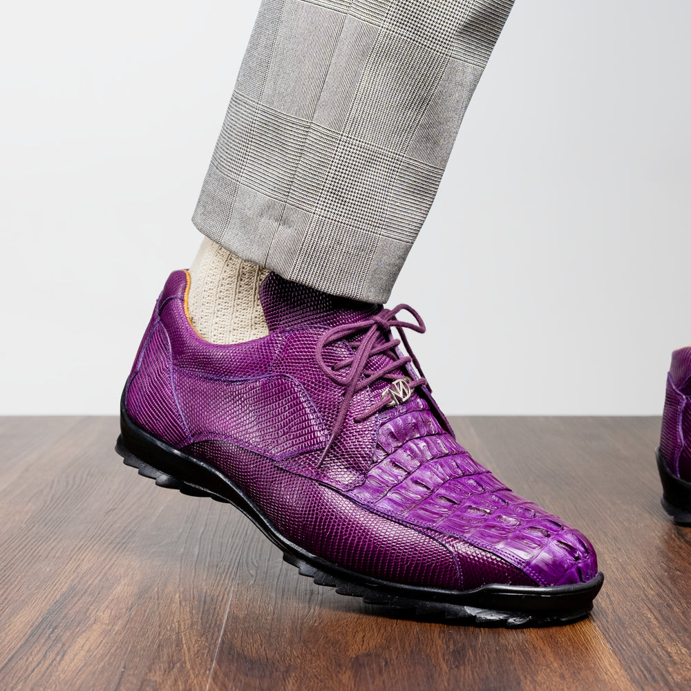 The Marco Di Milano Crater Purple sneakers showcase bold, textured elegance with their purple lizard skin and black rubber soles—luxury men’s footwear where one sneaker stands upright and the other leans.