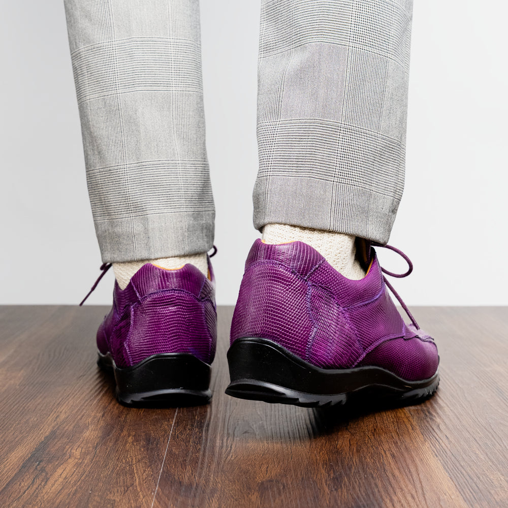 The Marco Di Milano Crater Purple sneakers showcase bold, textured elegance with their purple lizard skin and black rubber soles—luxury men’s footwear where one sneaker stands upright and the other leans.