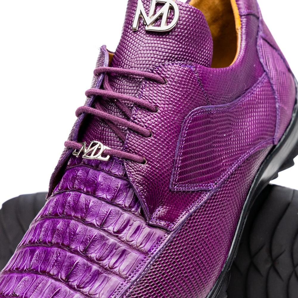 The Marco Di Milano Crater Purple sneakers showcase bold, textured elegance with their purple lizard skin and black rubber soles—luxury men’s footwear where one sneaker stands upright and the other leans.