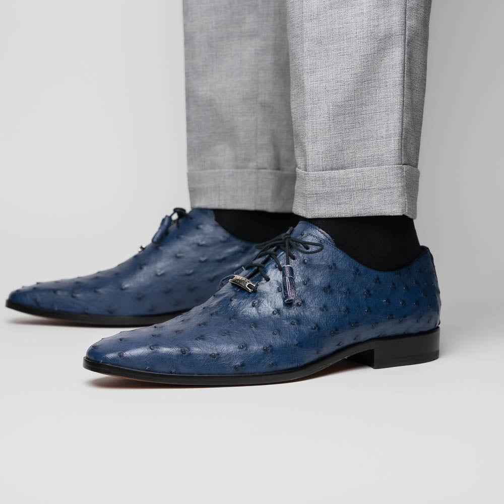 The Criss Navy by Marco Di Milano: a pair of genuine ostrich dress shoes with blue leather, black laces, red inner lining, and brown soles—one upright, one on its side—showcasing luxury men’s footwear.