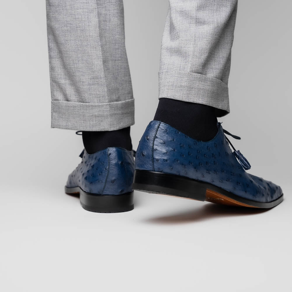 The Criss Navy by Marco Di Milano: a pair of genuine ostrich dress shoes with blue leather, black laces, red inner lining, and brown soles—one upright, one on its side—showcasing luxury men’s footwear.