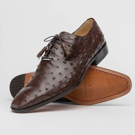 The Criss Brown by Marco Di Milano is a pair of luxury dress oxfords in dark brown genuine ostrich quill leather with decorative laces and a leather sole, shown with one shoe elegantly displayed on its side atop the other.