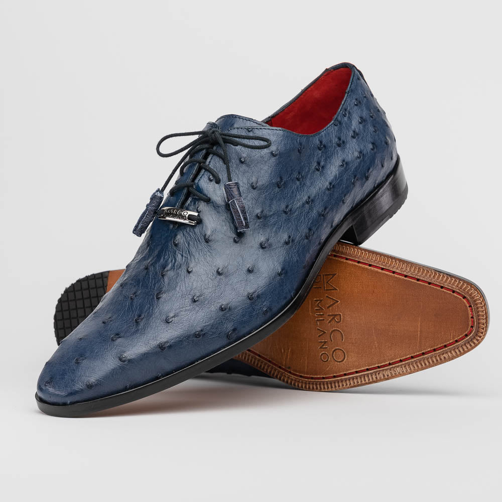 The Criss Navy by Marco Di Milano: a pair of genuine ostrich dress shoes with blue leather, black laces, red inner lining, and brown soles—one upright, one on its side—showcasing luxury men’s footwear.