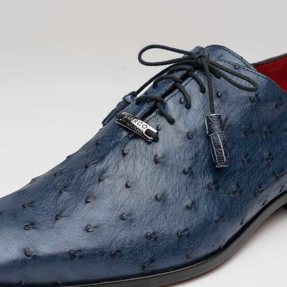 The Criss Navy by Marco Di Milano: a pair of genuine ostrich dress shoes with blue leather, black laces, red inner lining, and brown soles—one upright, one on its side—showcasing luxury men’s footwear.