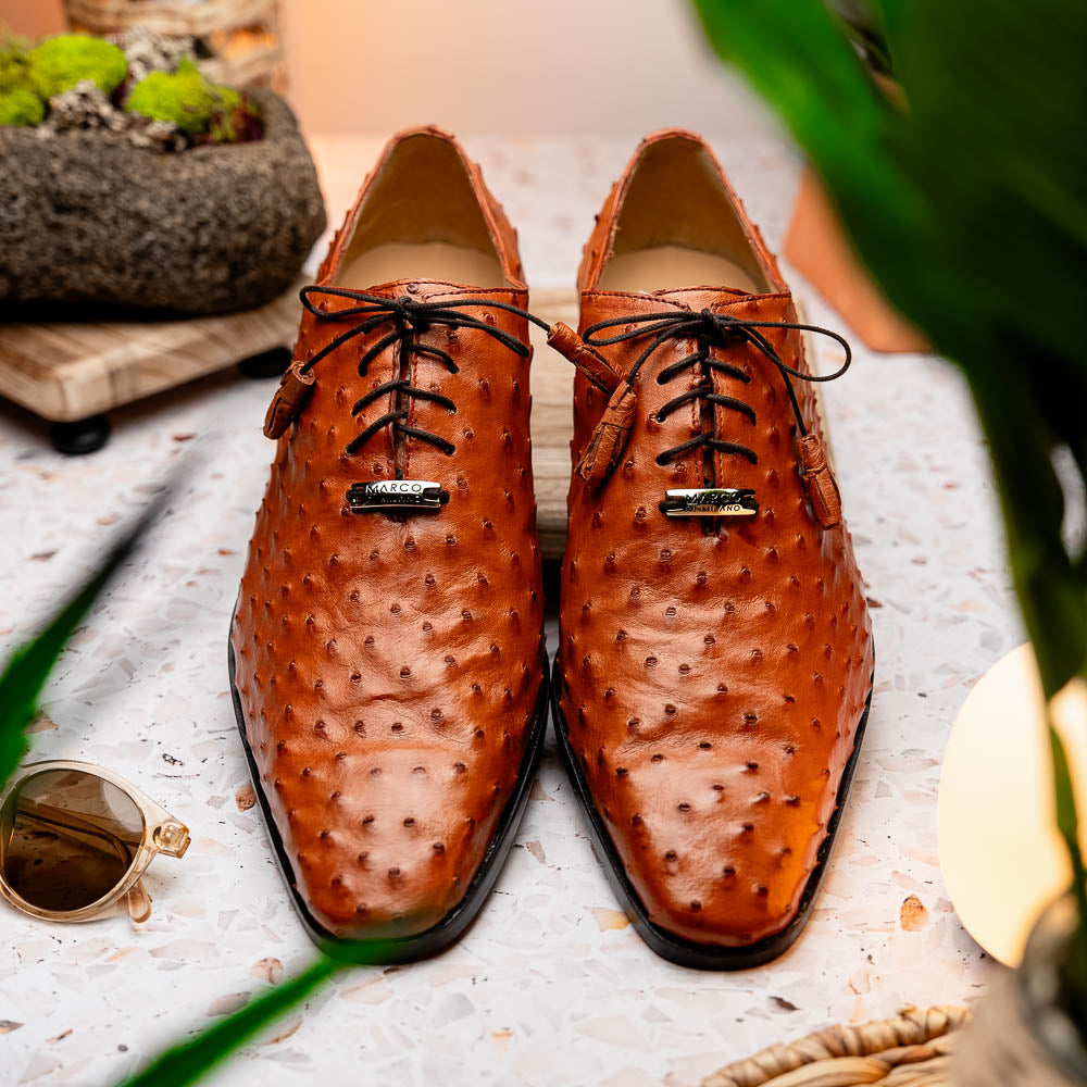 A pair of Criss Brandy genuine ostrich quill leather luxury dress oxfords by Marco Di Milano, with one shoe upright and the other sole up to display the brand name.