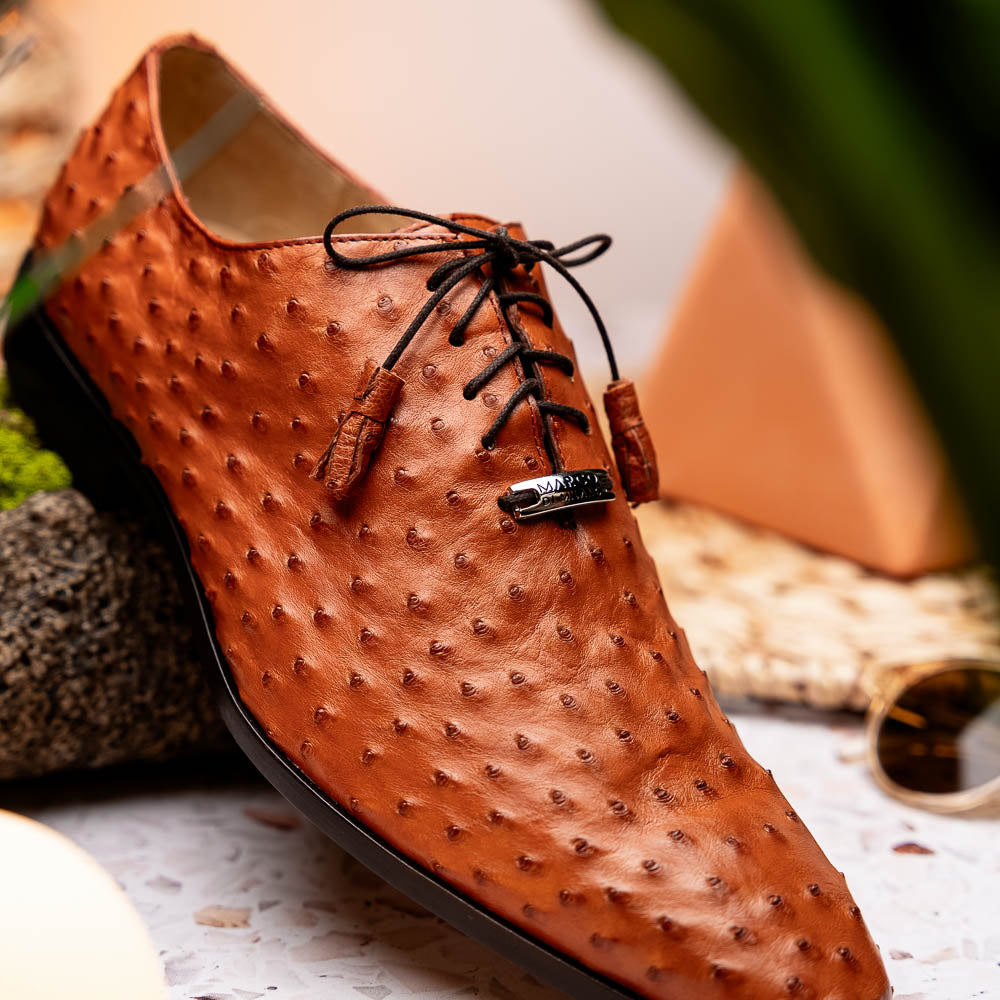 A pair of Criss Brandy genuine ostrich quill leather luxury dress oxfords by Marco Di Milano, with one shoe upright and the other sole up to display the brand name.