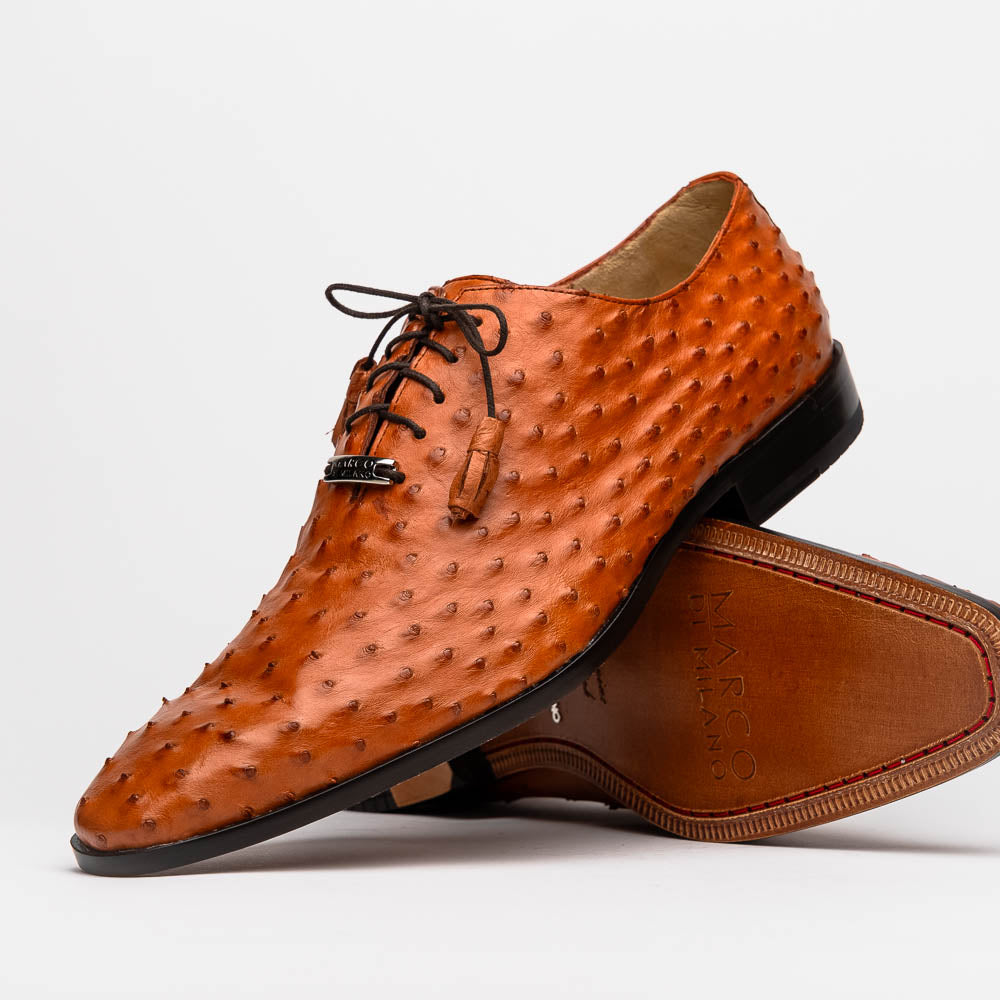 A pair of Criss Brandy genuine ostrich quill leather luxury dress oxfords by Marco Di Milano, with one shoe upright and the other sole up to display the brand name.