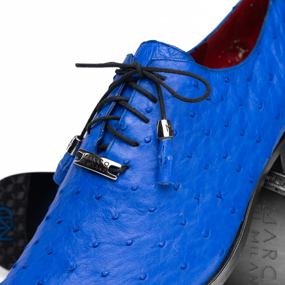 Introducing the Criss Electric Blue by Marco Di Milano—a pair of vibrant blue genuine ostrich quill leather oxford dress shoes featuring stylish laces and sleek metal detailing. One shoe stands upright while the other displays its beautifully crafted sole, making them an exceptional choice for anyone looking for distinctive luxury footwear.