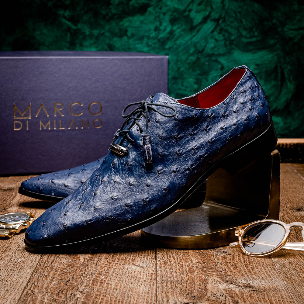 The Criss Navy by Marco Di Milano: a pair of genuine ostrich dress shoes with blue leather, black laces, red inner lining, and brown soles—one upright, one on its side—showcasing luxury men’s footwear.