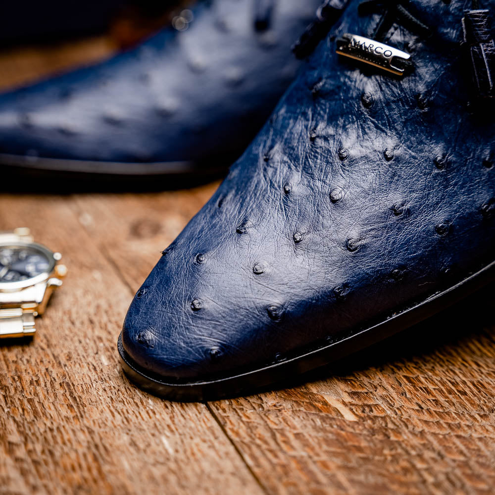 The Criss Navy by Marco Di Milano: a pair of genuine ostrich dress shoes with blue leather, black laces, red inner lining, and brown soles—one upright, one on its side—showcasing luxury men’s footwear.