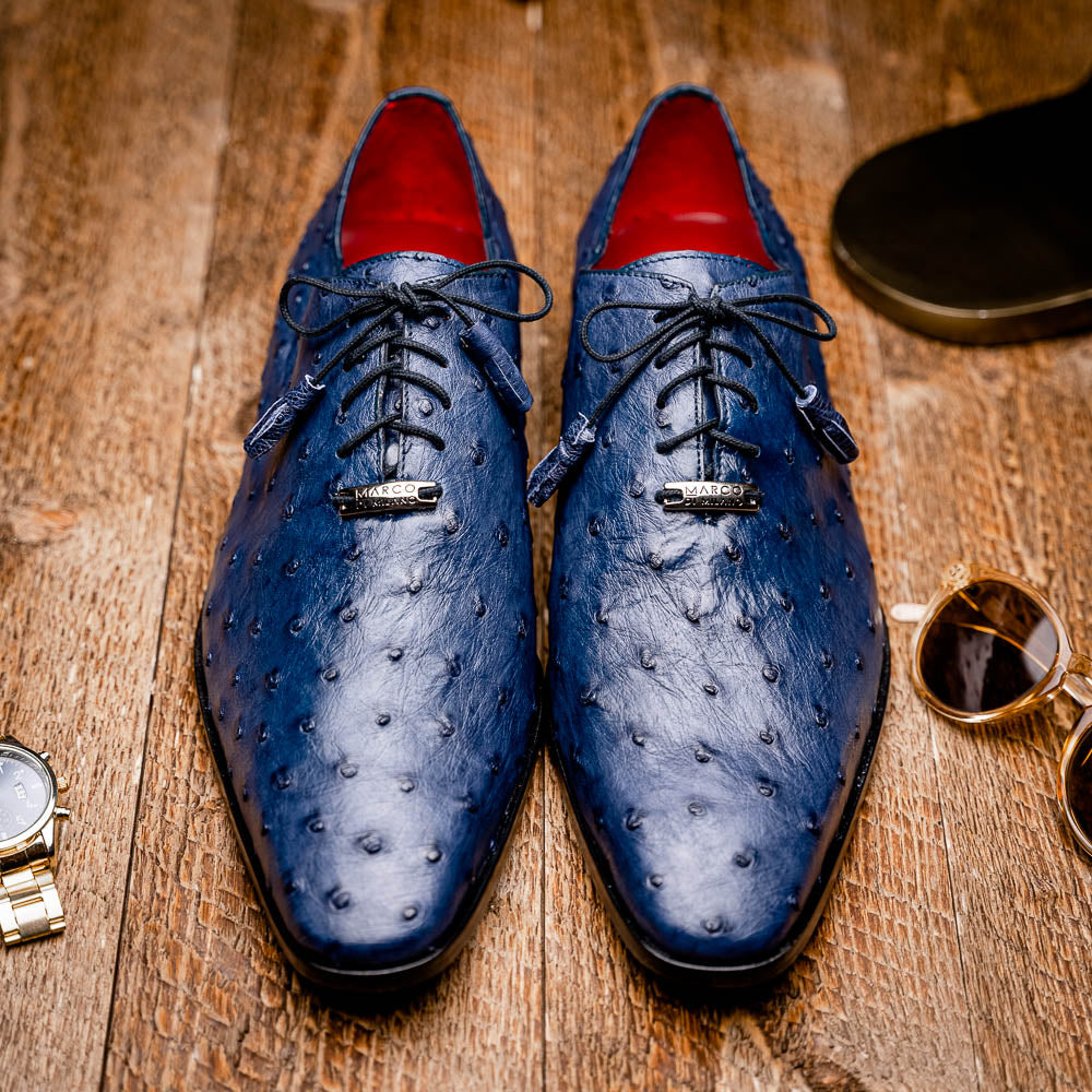 The Criss Navy by Marco Di Milano: a pair of genuine ostrich dress shoes with blue leather, black laces, red inner lining, and brown soles—one upright, one on its side—showcasing luxury men’s footwear.