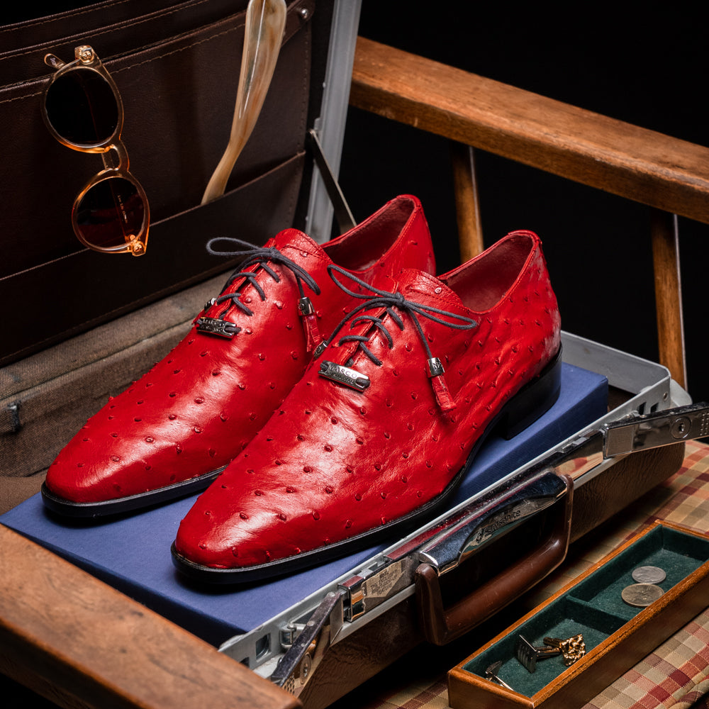 Introducing the Criss Red by Marco Di Milano: a pair of striking red genuine ostrich quill leather dress oxford shoes with black laces—one elegantly upright and the other displayed on its side to showcase the luxurious sole. This luxury footwear commands attention at every step.