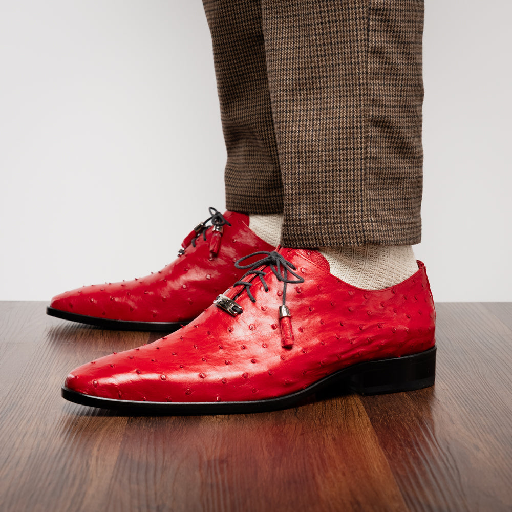 Introducing the Criss Red by Marco Di Milano: a pair of striking red genuine ostrich quill leather dress oxford shoes with black laces—one elegantly upright and the other displayed on its side to showcase the luxurious sole. This luxury footwear commands attention at every step.
