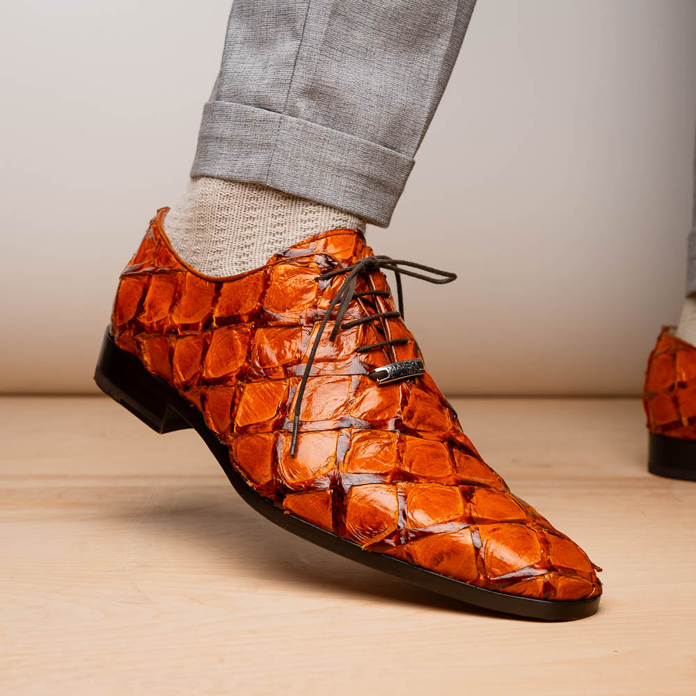 A pair of Olivieri Brandy by Marco Di Milano luxury dress oxford shoes in orange-brown crocodile leather with dark laces, one shoe shown on its side highlighting the branded sole.