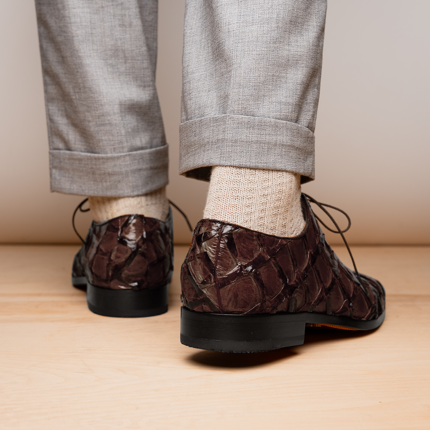 A pair of Olivieri Brown oxford shoes by Marco Di Milano—one upright, one on its side revealing the branded sole—showcase luxurious crocodile leather craftsmanship.