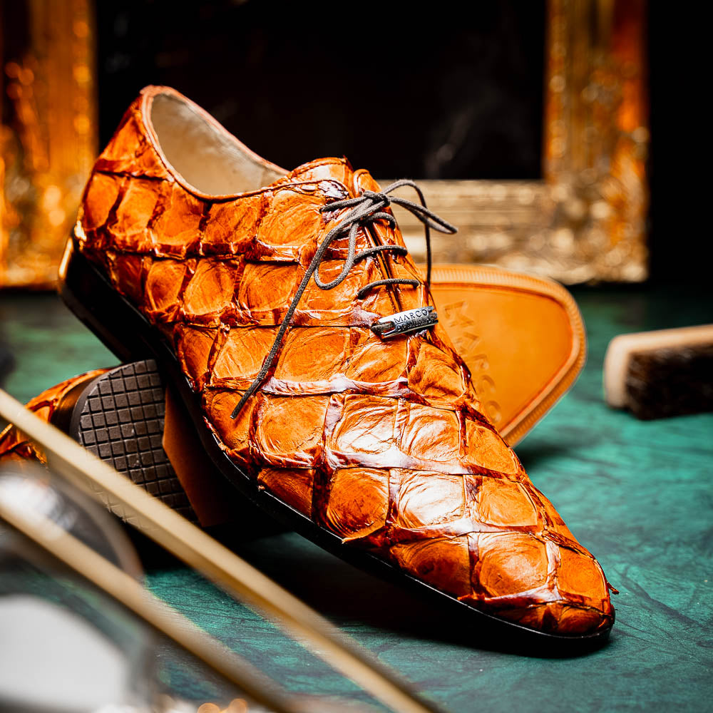 A pair of Olivieri Brandy by Marco Di Milano luxury dress oxford shoes in orange-brown crocodile leather with dark laces, one shoe shown on its side highlighting the branded sole.
