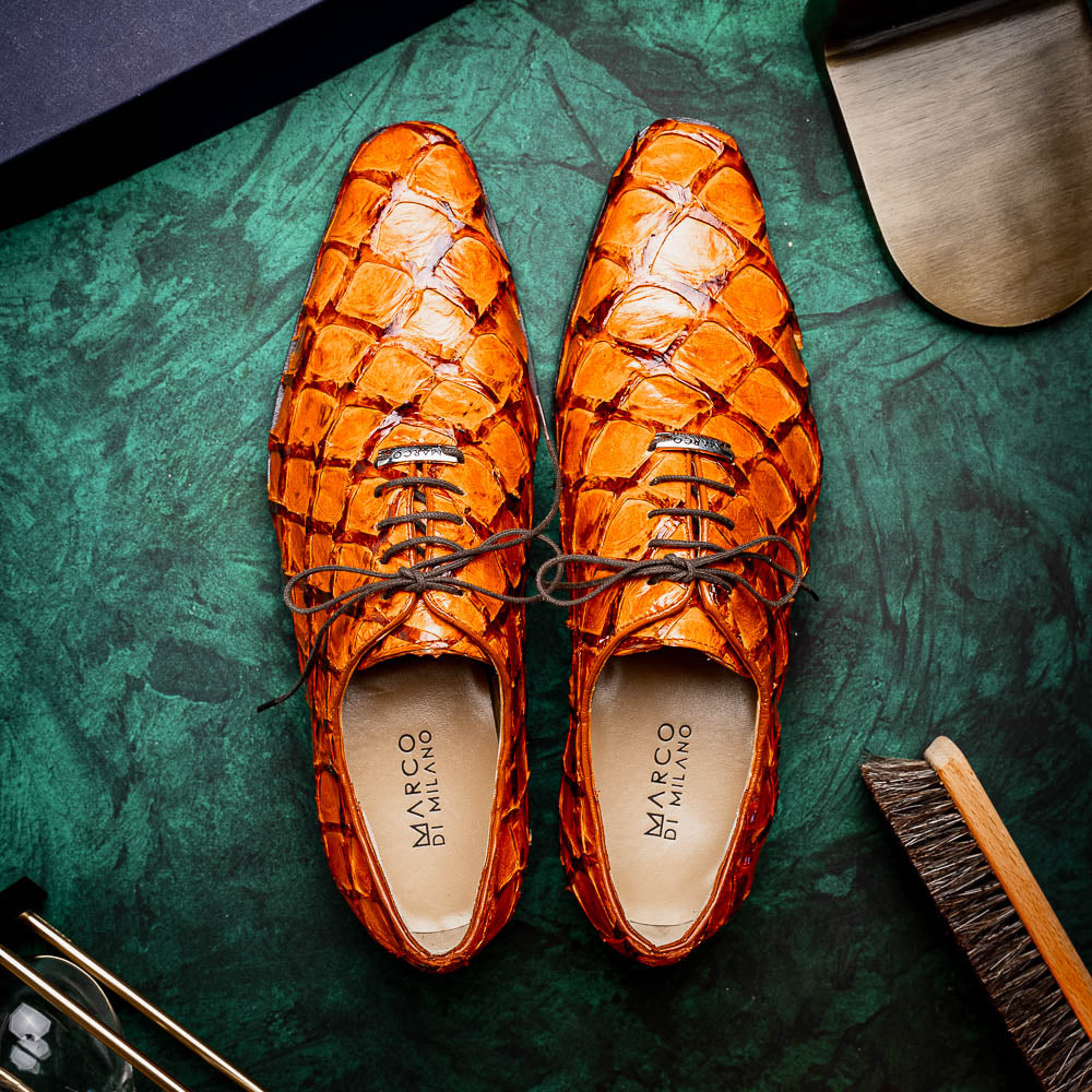 A pair of Olivieri Brandy by Marco Di Milano luxury dress oxford shoes in orange-brown crocodile leather with dark laces, one shoe shown on its side highlighting the branded sole.
