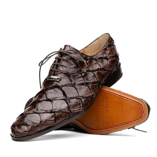 A pair of Olivieri Brown oxford shoes by Marco Di Milano—one upright, one on its side revealing the branded sole—showcase luxurious crocodile leather craftsmanship.