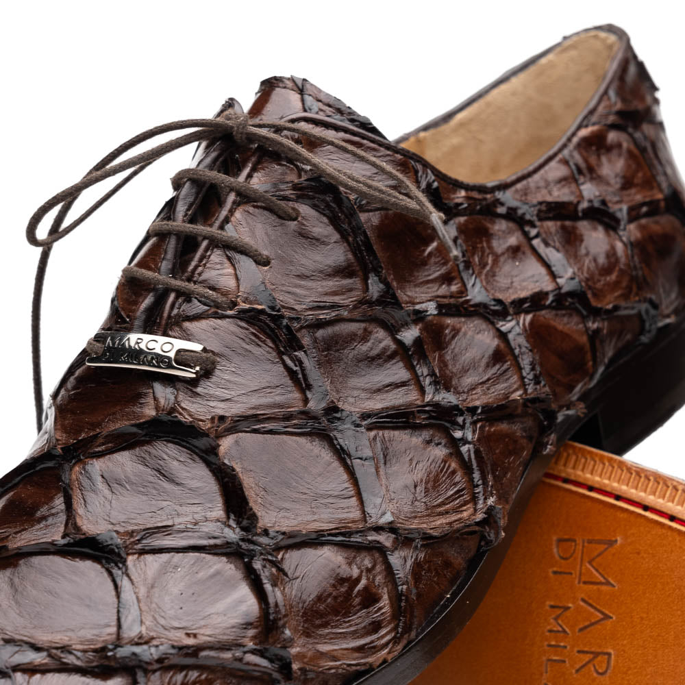 A pair of Olivieri Brown oxford shoes by Marco Di Milano—one upright, one on its side revealing the branded sole—showcase luxurious crocodile leather craftsmanship.